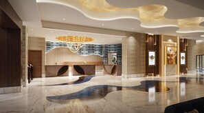 Eine moderne Lobby mit Marmorboden, einer Rezeption und einer Kristallleuchtre.'