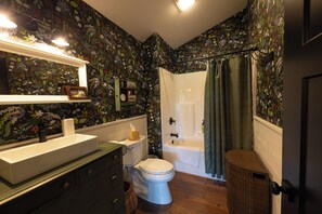 Een badkamer met een wit wastafel, toilet en bad.