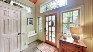 A wooden interior with a bench, a door, and a lamp. - Acorn Cottage by Taylor Made Deep Creek (Oakland)