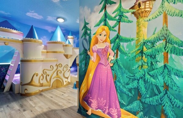Una habitación con una zona de juegos temática de castillo, un mural de una princesa y una escena de bosque.