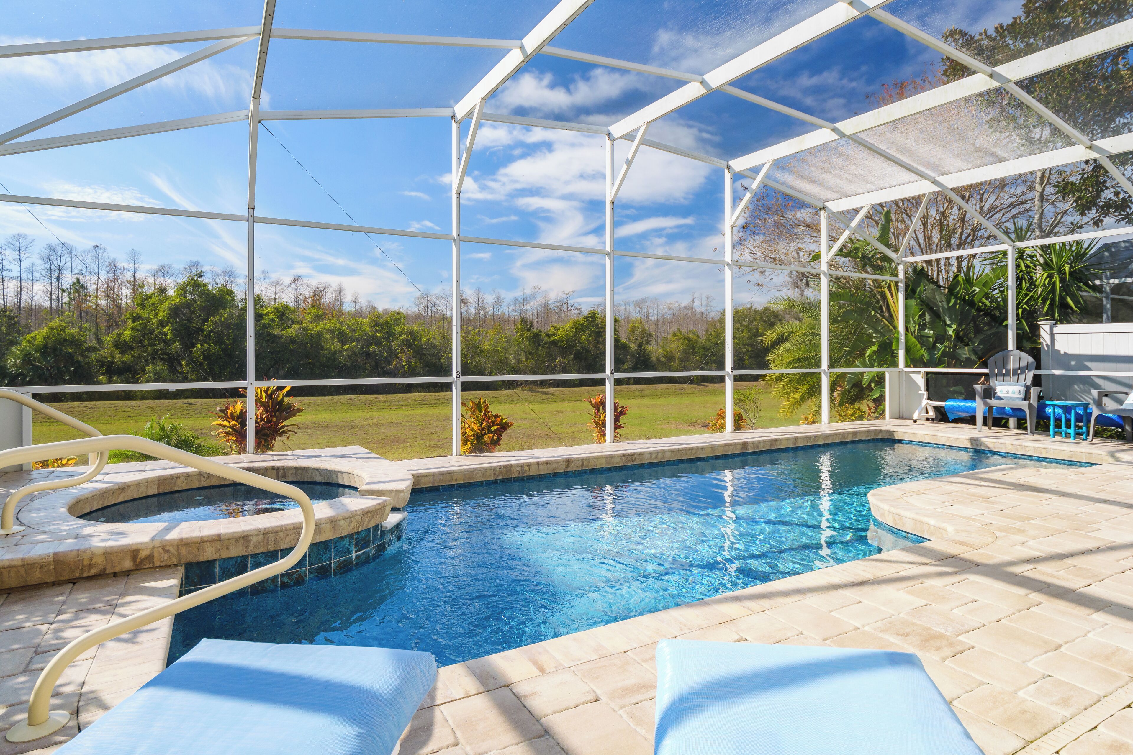 Une piscine couverte avec vue sur une zone verdoyante et des arbres.