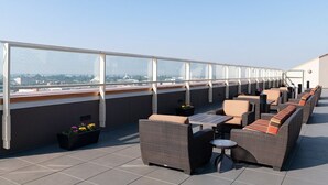 A rooftop terrace with wicker furniture, a small table, and potted plants. - WorldMark Anaheim - 2 Bedroom Presidential Accessible (Anaheim)