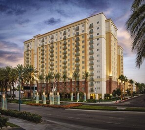 A multi-story hotel with a uniform facade, balconies, and a landscaped entrance area with palm trees. - WorldMark Anaheim - 2 Bedroom Accessible (Anaheim)