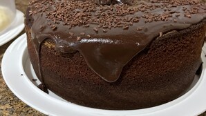 A chocolate cake with chocolate sprinkles on a white plate. - Pousada Sanhaço (Angra dos Reis)