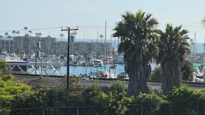 Uma marina com barcos, uma ponte e palmeiras.