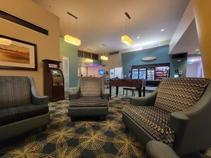 A lobby with seating, a reception desk, and a vending machine.