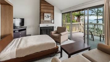 Habitación de hotel con cama, televisión, sofá, mesita de centro y balcón con vistas al mar.