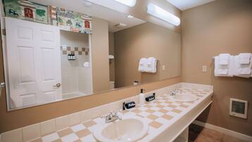 Un baño con dos lavamanos, un espejo grande y un salpicadero de azulejos a cuadros.