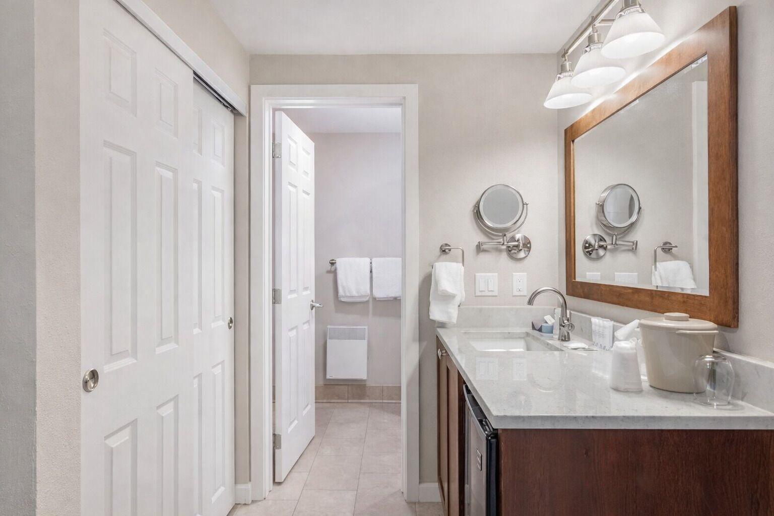 A modern bathroom with a double sink, a large mirror, and a walk-in shower.