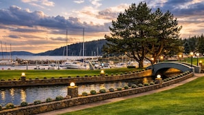 A marina with boats, a stone bridge, and a well-maintained grassy area. - Rosario Resort (Eastsound)
