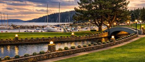 A marina with boats, a stone bridge, and a well-maintained grassy area.