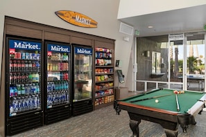 A pool table, vending machines, and a sign for restrooms.