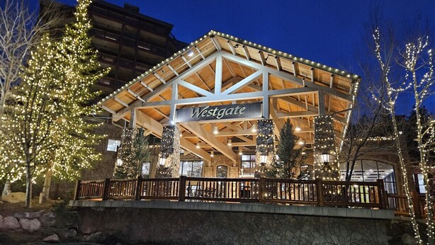 A Westgate building with a wooden facade, stone pillars, and a stone retaining wall. - Ski in and out, Canyons, Westgate, King, Kitchen, Free Breakfast, Coffee & Tea Bar, Steam, Pool, HT (Park City)