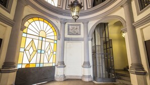 An interior with a large stained glass window, a staircase, and classical architectural elements. - Corso 142 elegant apartment within walking distance of Piazza Navona (Roma)