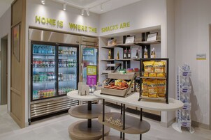 Una presentación de aperitivos con un cartel que dice 'Home is where the snacks are', una zona refrigerada para bebidas y un cartel con la palabra 'hello' sobre una mesa.