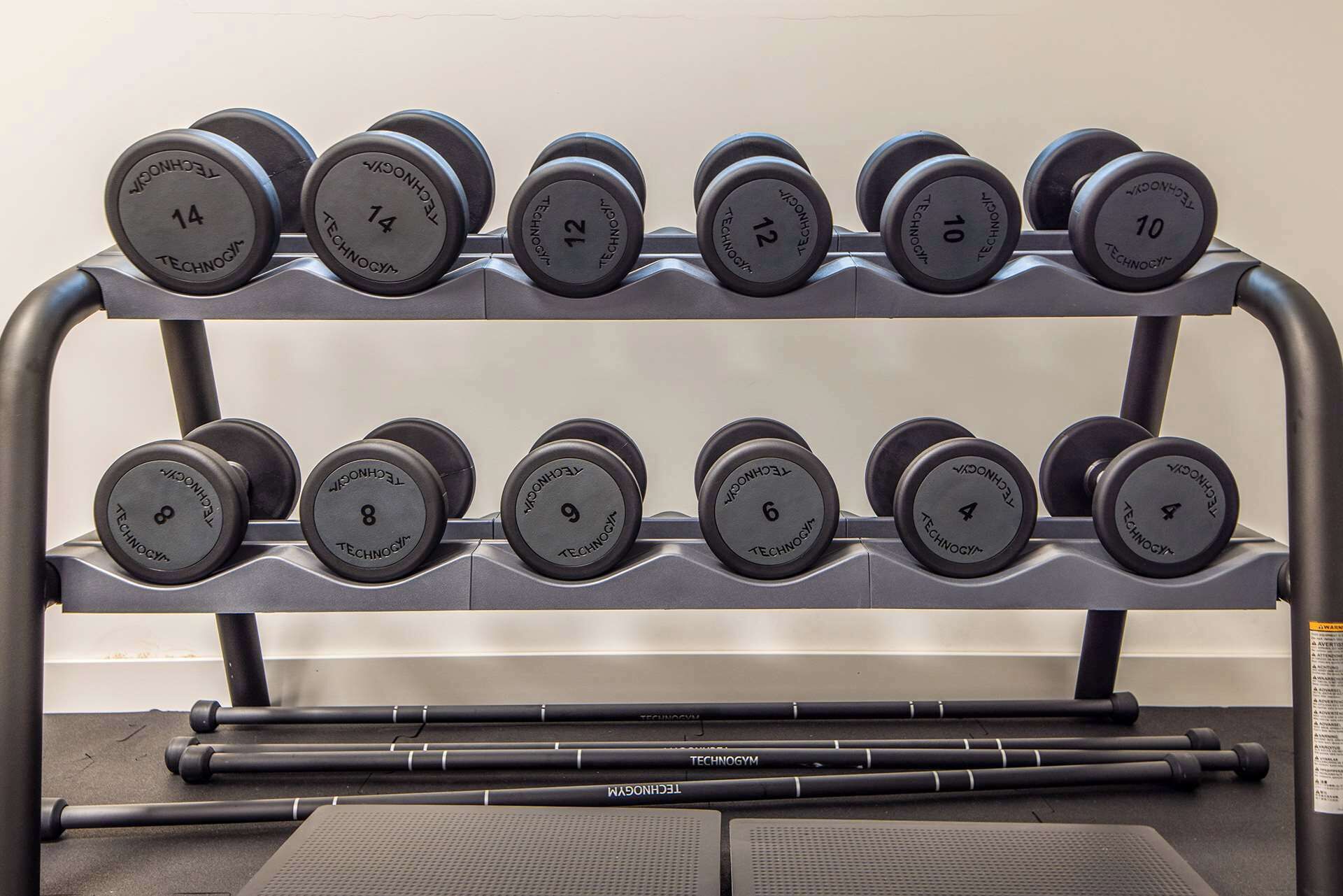 A rack of dumbbells with weights ranging from 4 to 14 kilograms.