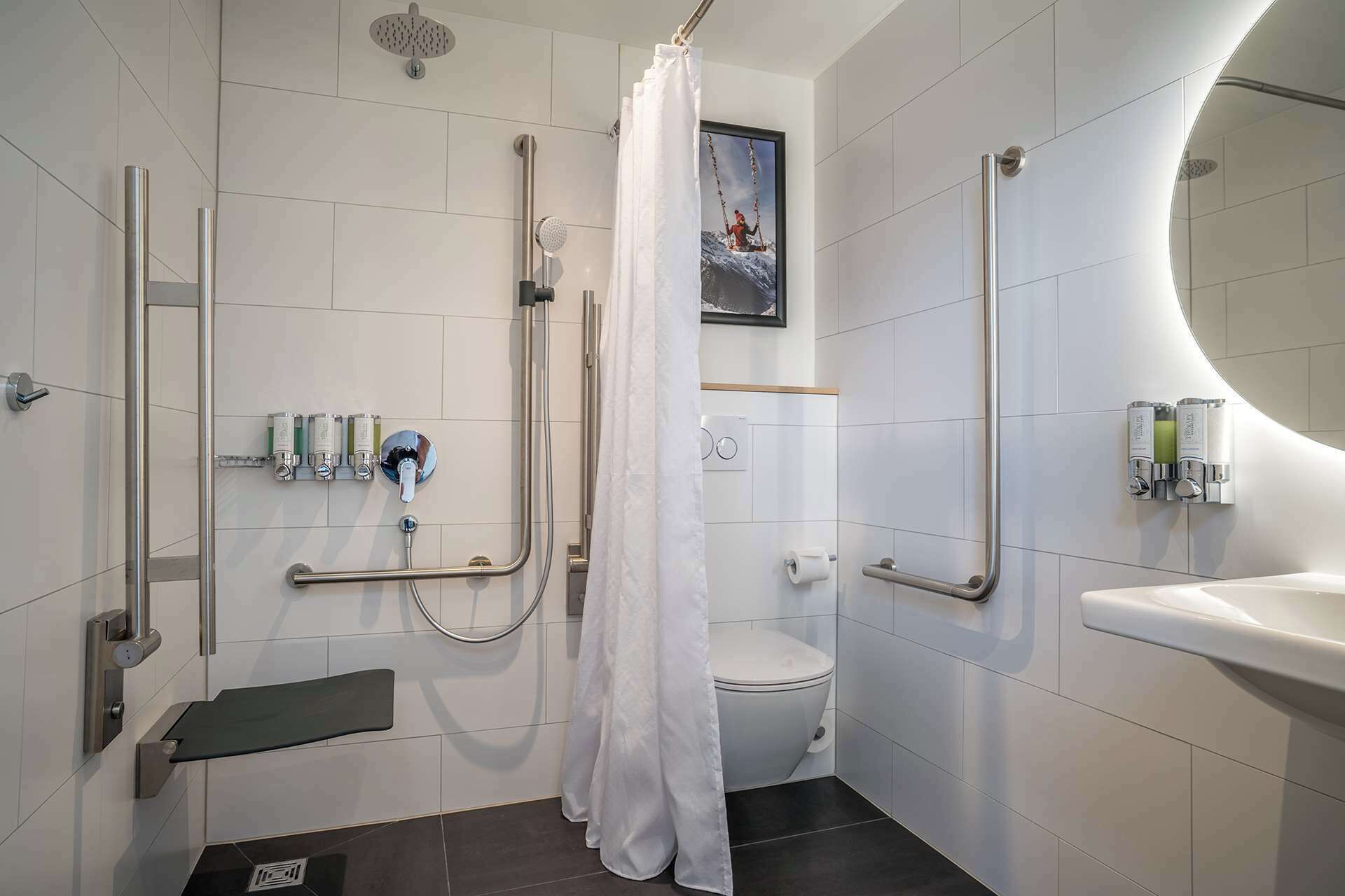 Uma casa de banho moderna com chuveiro, sanita e lavatório.