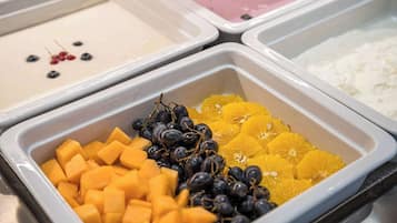 Eine Auswahl an Obst und Joghurt in einem Buffet-Bereich.