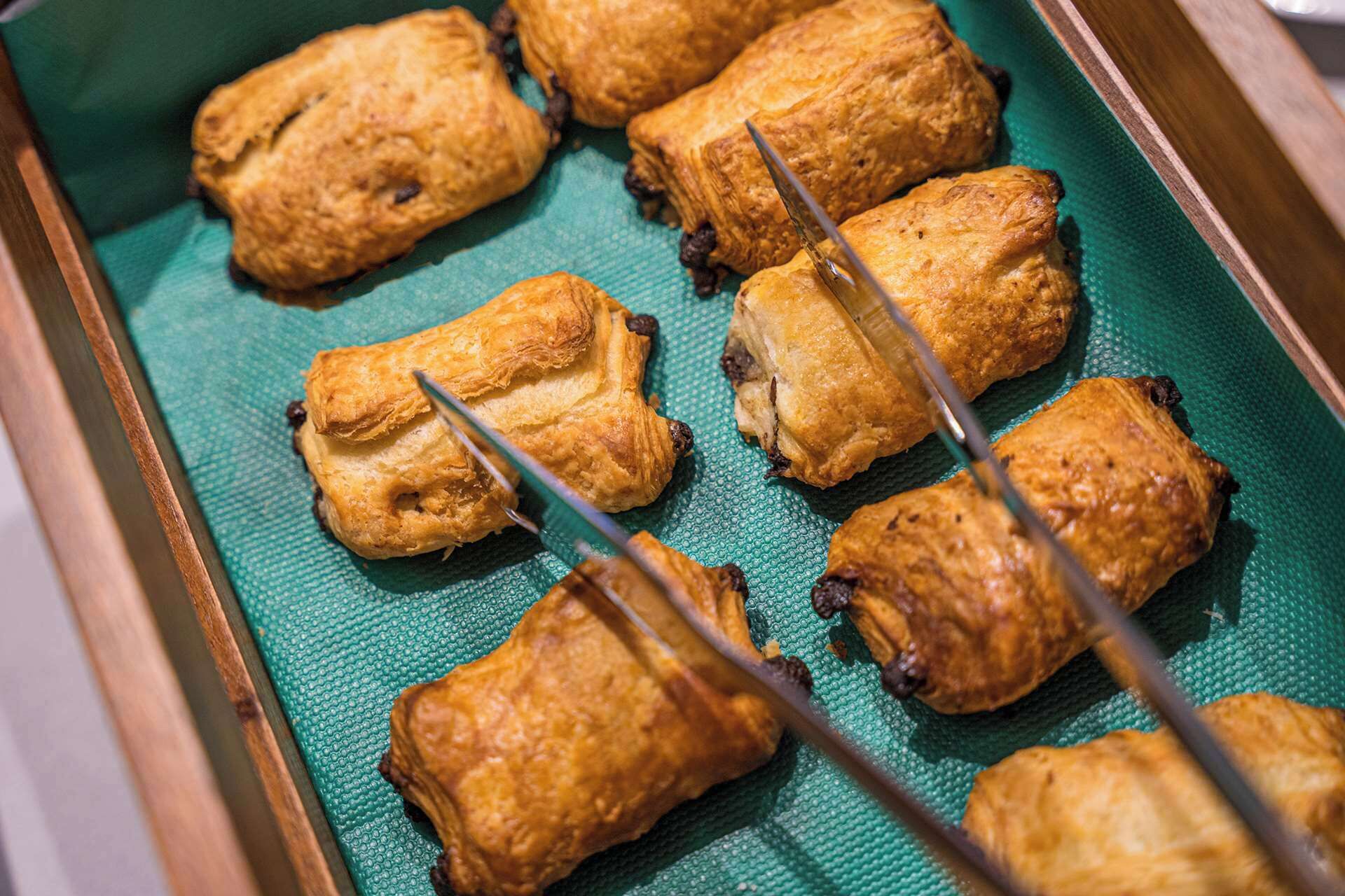 A tray of golden-brown pastries on a green surface.