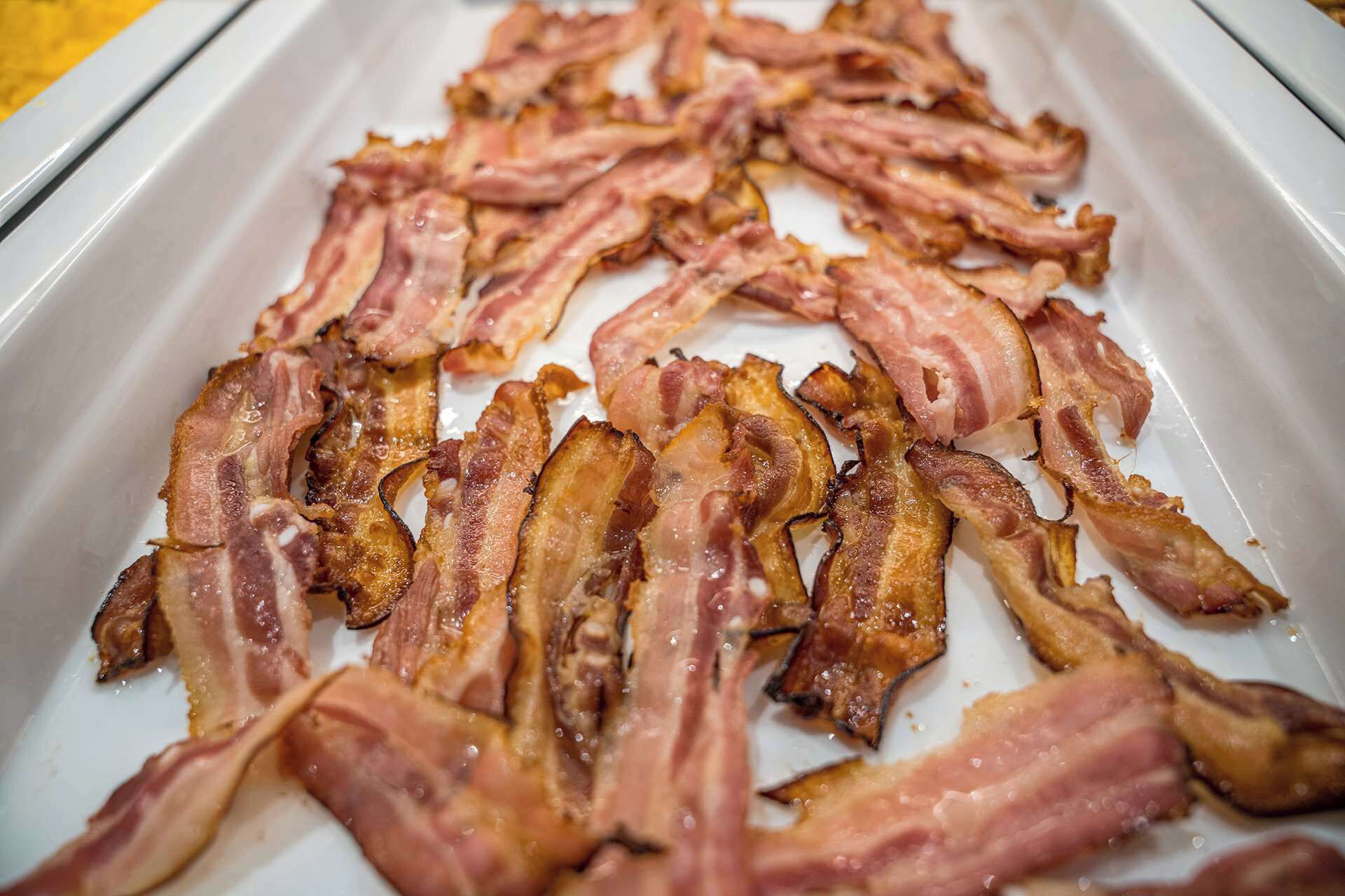 A tray of cooked bacon strips.