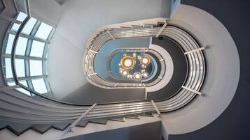 A spiral staircase with a central open area and a skylight.