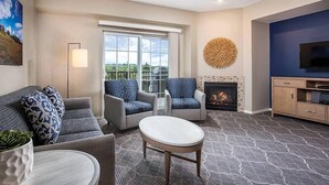 A living room with a fireplace, a TV, and a large window. - WorldMark Solvang - 2 Bedroom Twin Accessible (Solvang)