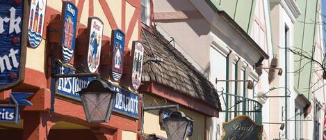 Una calle con varios comercios, incluyendo un bar llamado 'The Cowboy Way Bar-B-Que'.