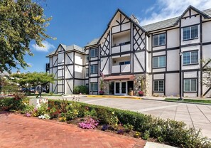 A modern hotel with a Tudor-style facade, a central entrance, and a landscaped garden area. - Solvang | Village Wine Escape | Pool & Walkable Downtown (Solvang)