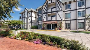 A modern hotel with a Tudor-style facade, a central entrance, and a landscaped garden area. - Solvang | Wine Country Hideaway | Pool & Village Walks (Solvang)