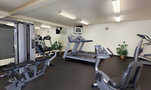 A gym with treadmills, weight machines, and a mirror. - Solvang | Wine Country Hideaway | Pool & Village Walks (Solvang)