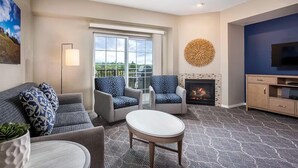 A modern living room with a fireplace, a television, and a balcony with a view. - WorldMark Solvang - 3 Bedroom (Solvang)