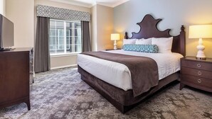 A hotel room with a large bed, a dresser, a nightstand with a lamp, and a window with curtains. - WorldMark Solvang - 3 Bedroom (Solvang)