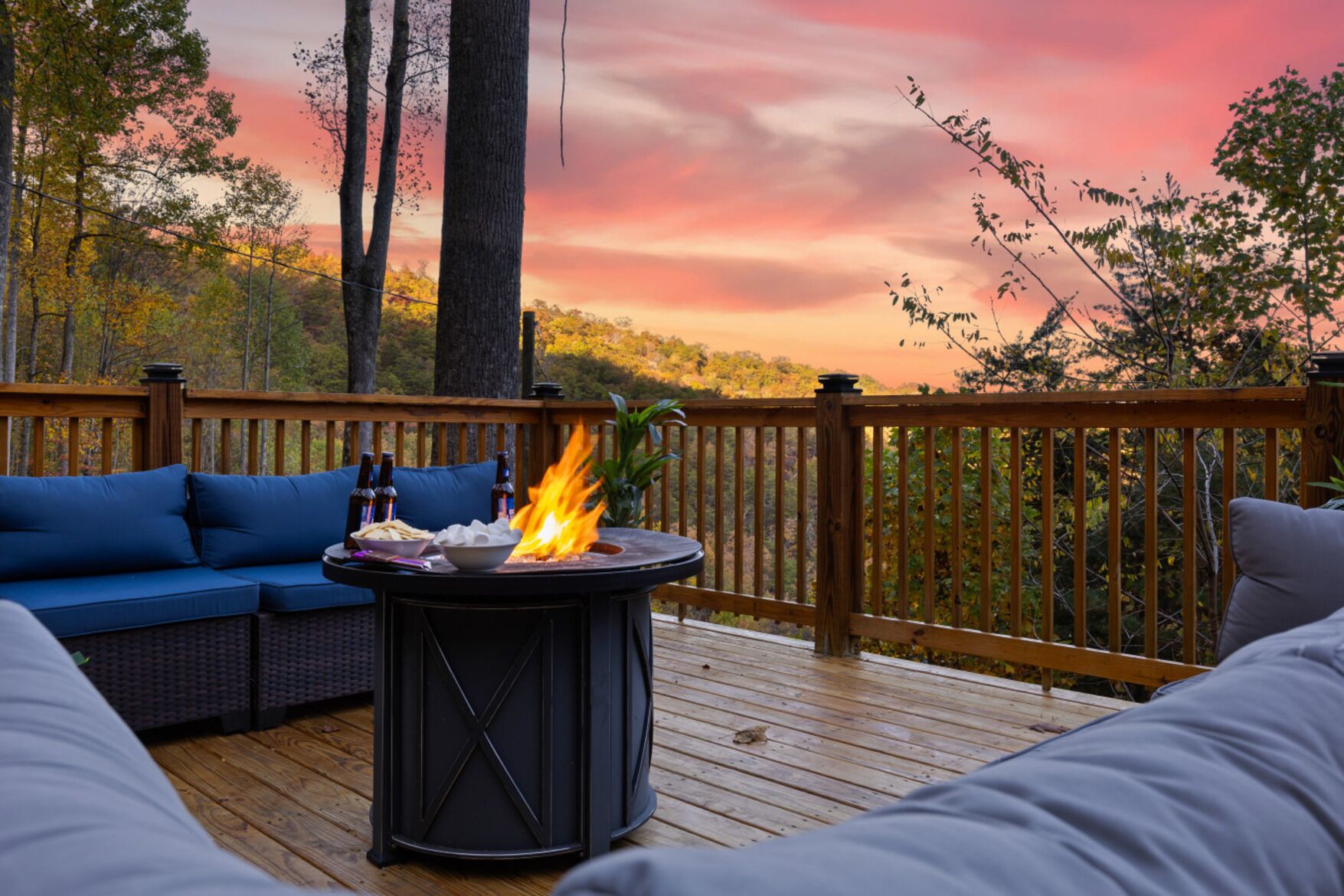 Une terrasse avec une table ronde, des coussins bleus et un foyer.