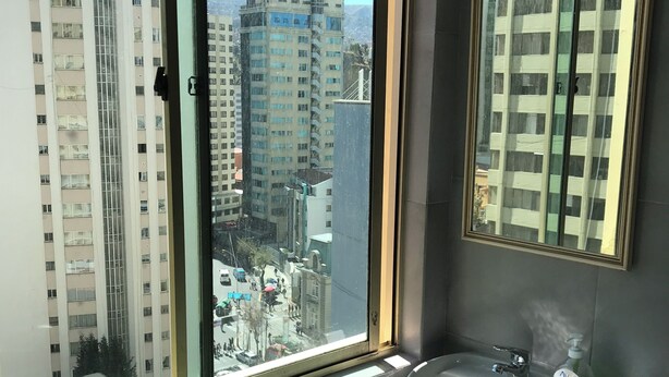 A bathroom with a large window, a sink, and a toilet. - Private Apartment on Arce Avenue (La Paz)
