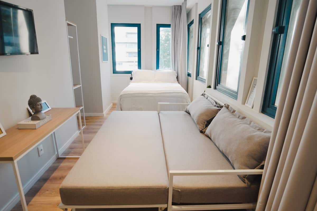 Ein modernes Schlafzimmer mit Bett, Nachttisch und Fernseher.