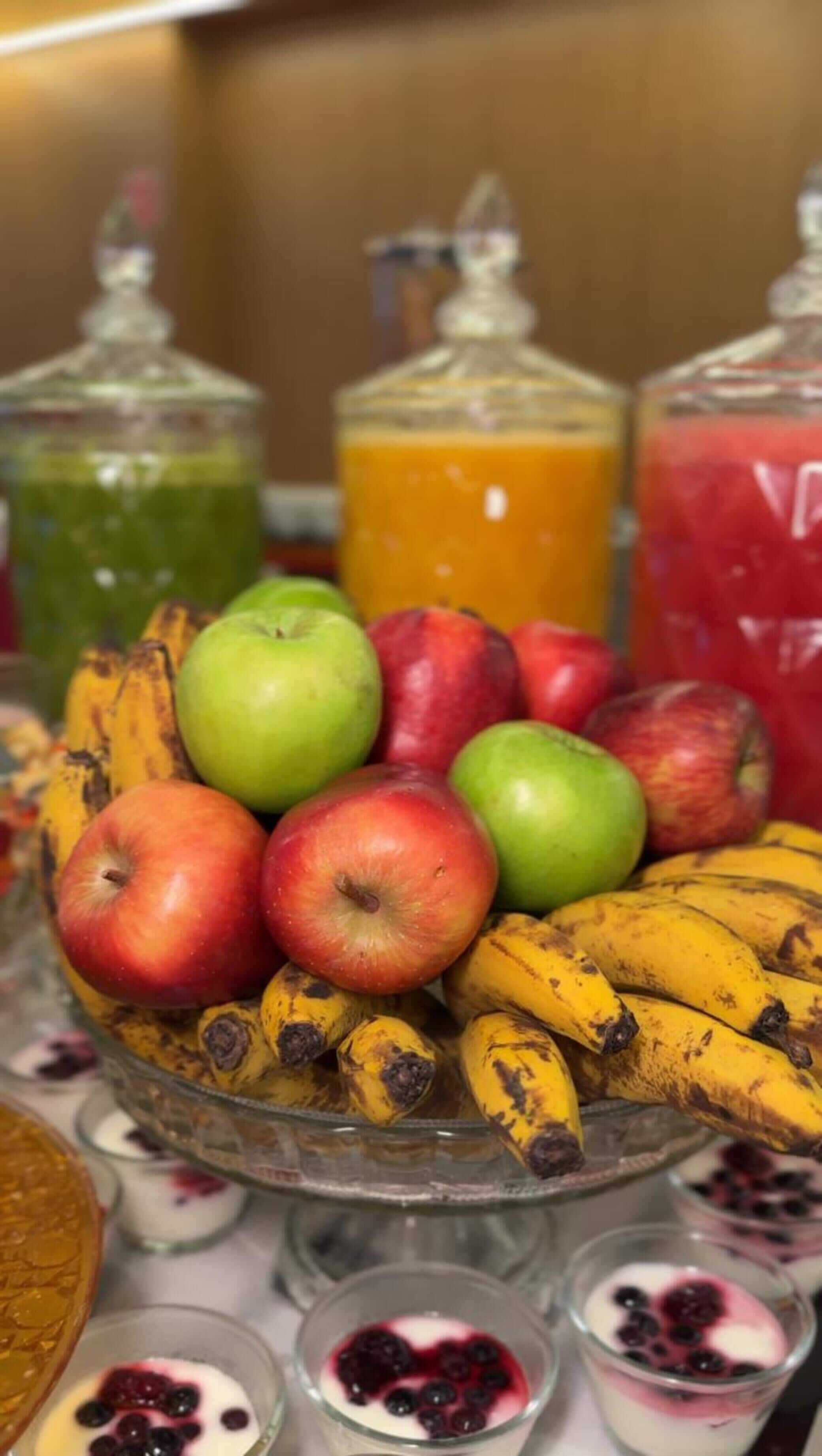 A fruit display with apples, bananas, and various juices.
