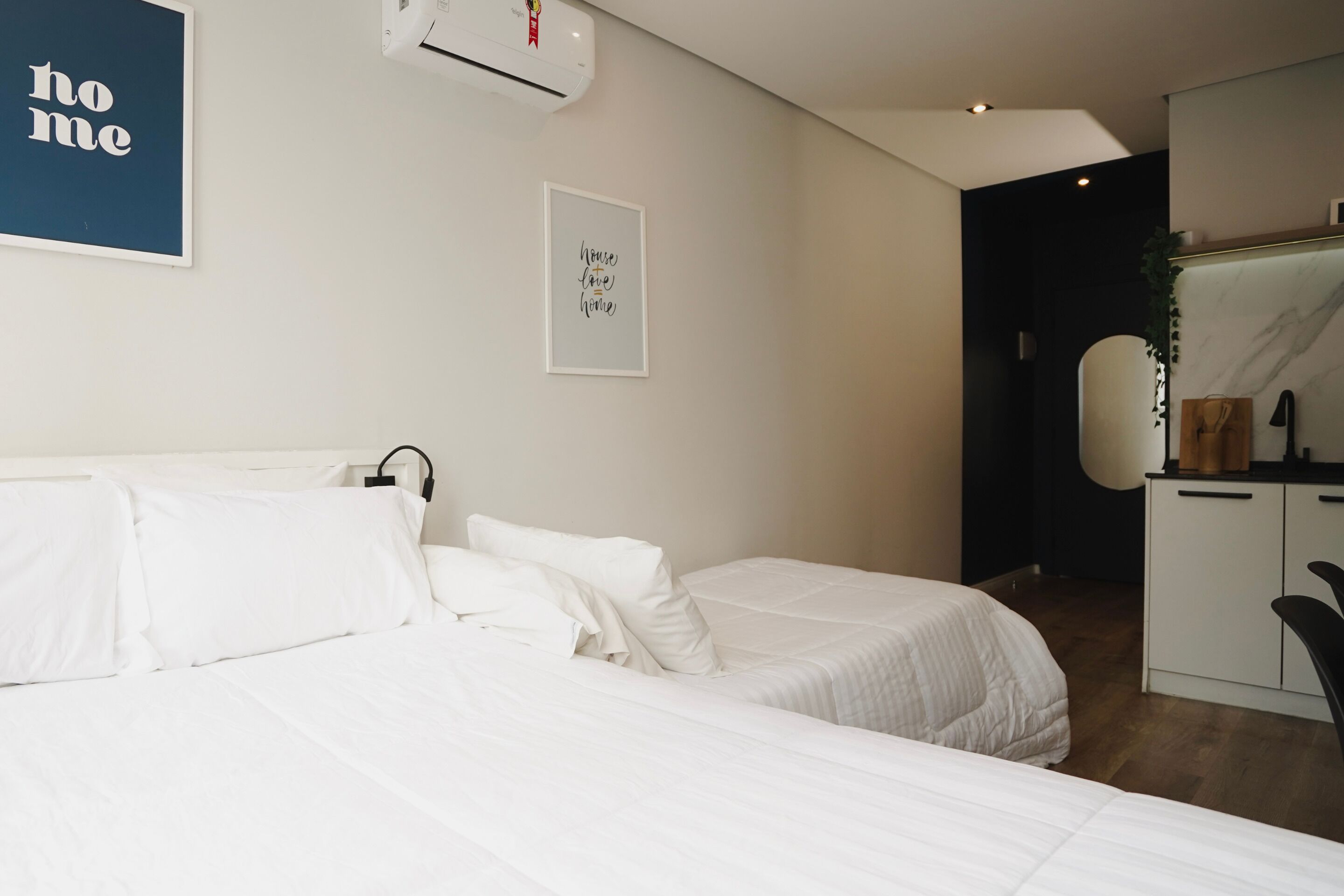 A bedroom with two beds, a wardrobe, and a desk.
