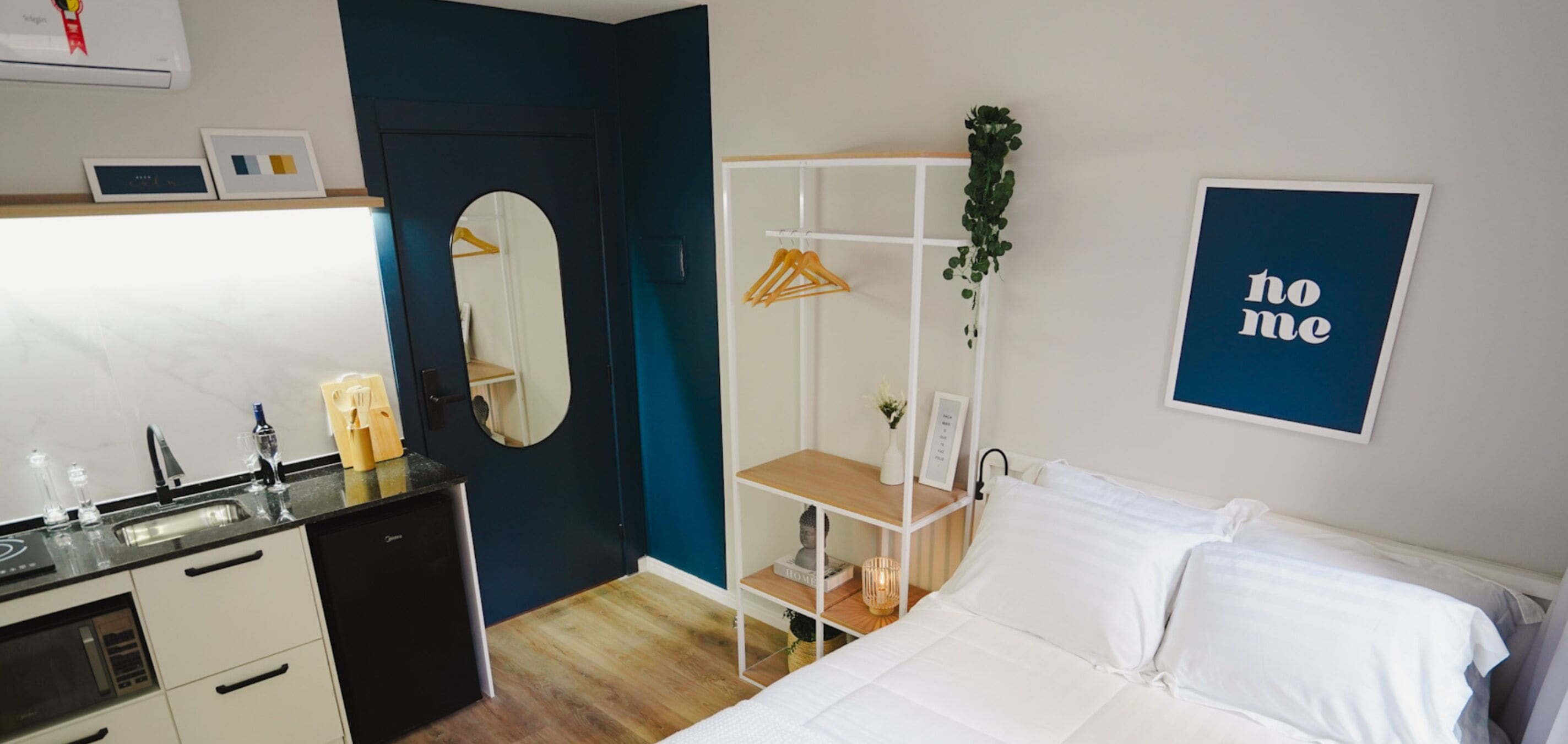 Une chambre à coucher avec un lit, une commode, un miroir, une armoire et un panneau indiquant « chez nous » sur le mur.