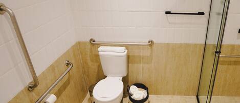 A bathroom with a white toilet, a bidet, and a glass shower enclosure.