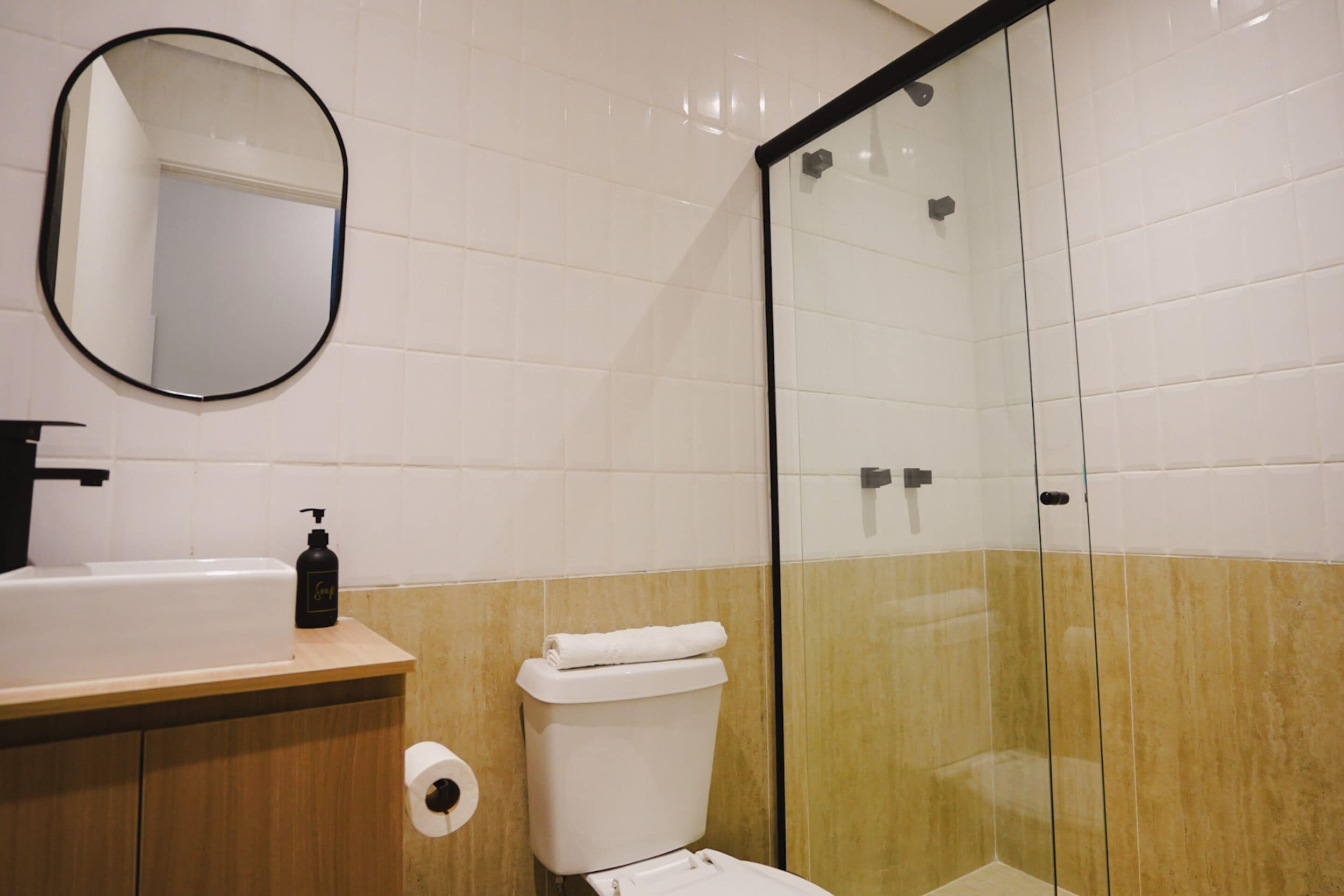 A bathroom with a sink, toilet, and a glass-enclosed shower.