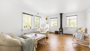 A spacious living room with a fireplace, large windows, and a cozy seating area.