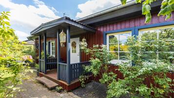 Ett hus med en veranda, en ytterdörr och ett fönster.