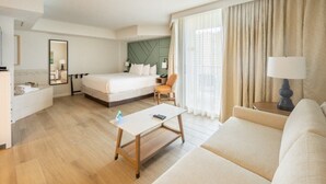 Hotellihuone, jossa on sänky, sohva, työpöytä ja tuoli.