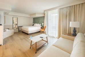 A hotel room with a bed, a sofa, a desk, and a chair.