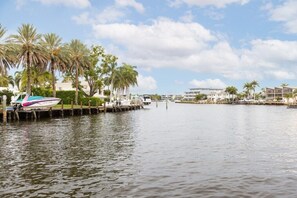A marina with boats docked, palm trees, and buildings in the background. - Pompano Beach | Couples Ocean Weekend | Pool + Beach (Pompano)
