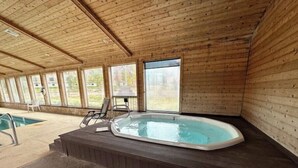 Una cabaña de madera con jacuzzi y piscina.
