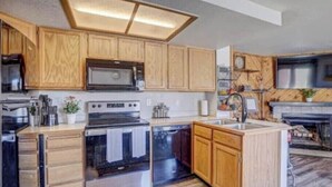 Una cocina moderna con gabinetes de madera, electrodomésticos de acero inoxidable y un horno empotrado.
