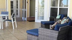 Un espace patio aménagé avec des meubles en osier, une table et des chaises.