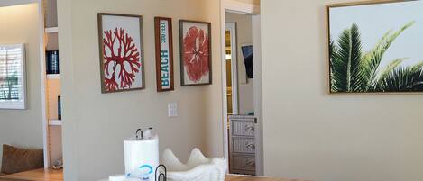 A room with a wooden counter, a white decorative item, and framed artwork on the wall.
