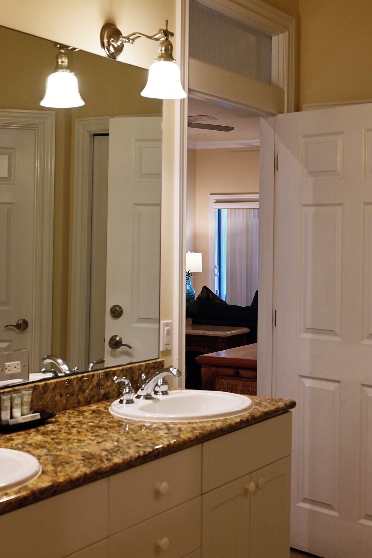 A bathroom with a sink, mirror, and two wall-mounted lights.